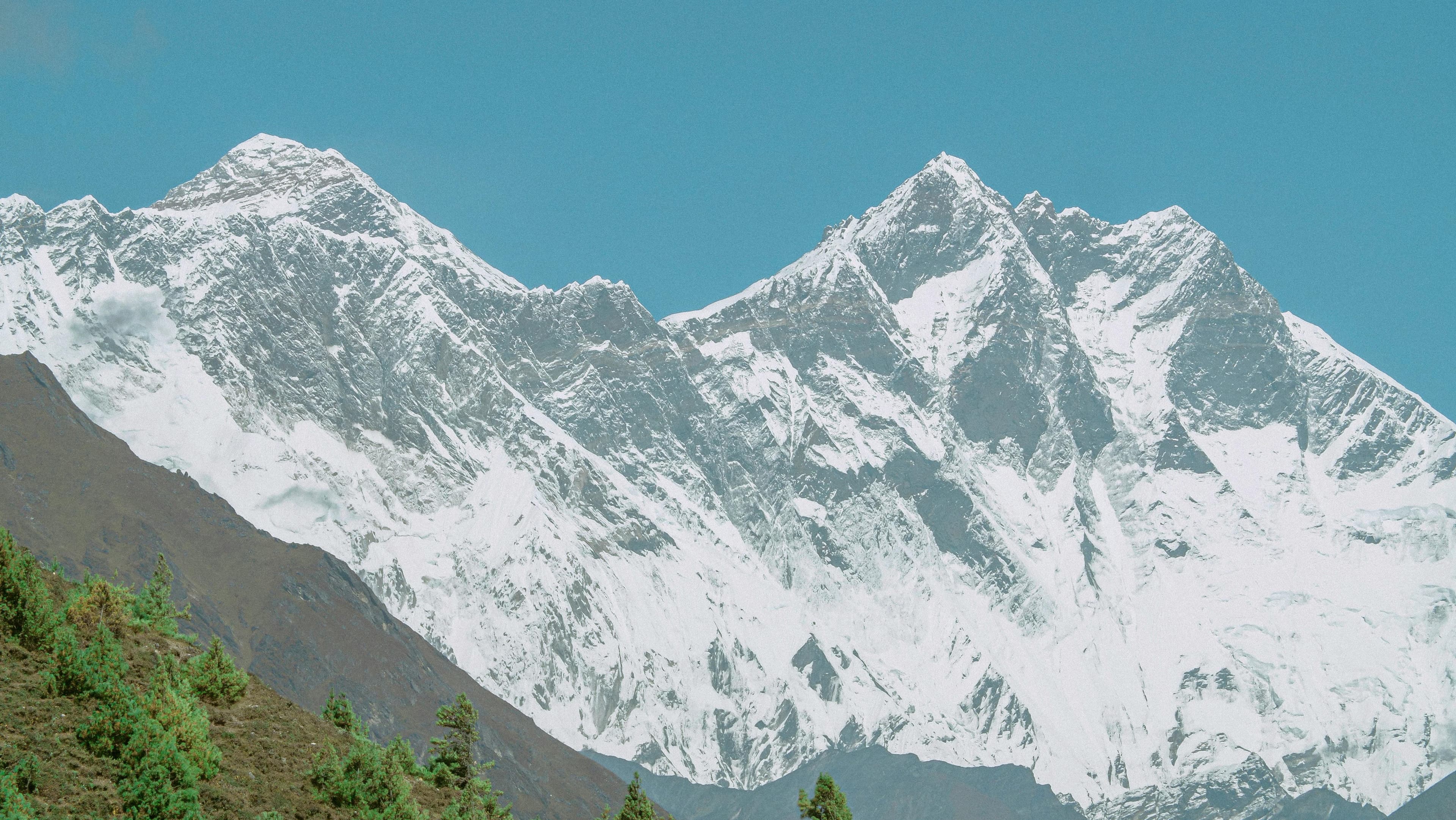 Snow face of Everest above a green valley