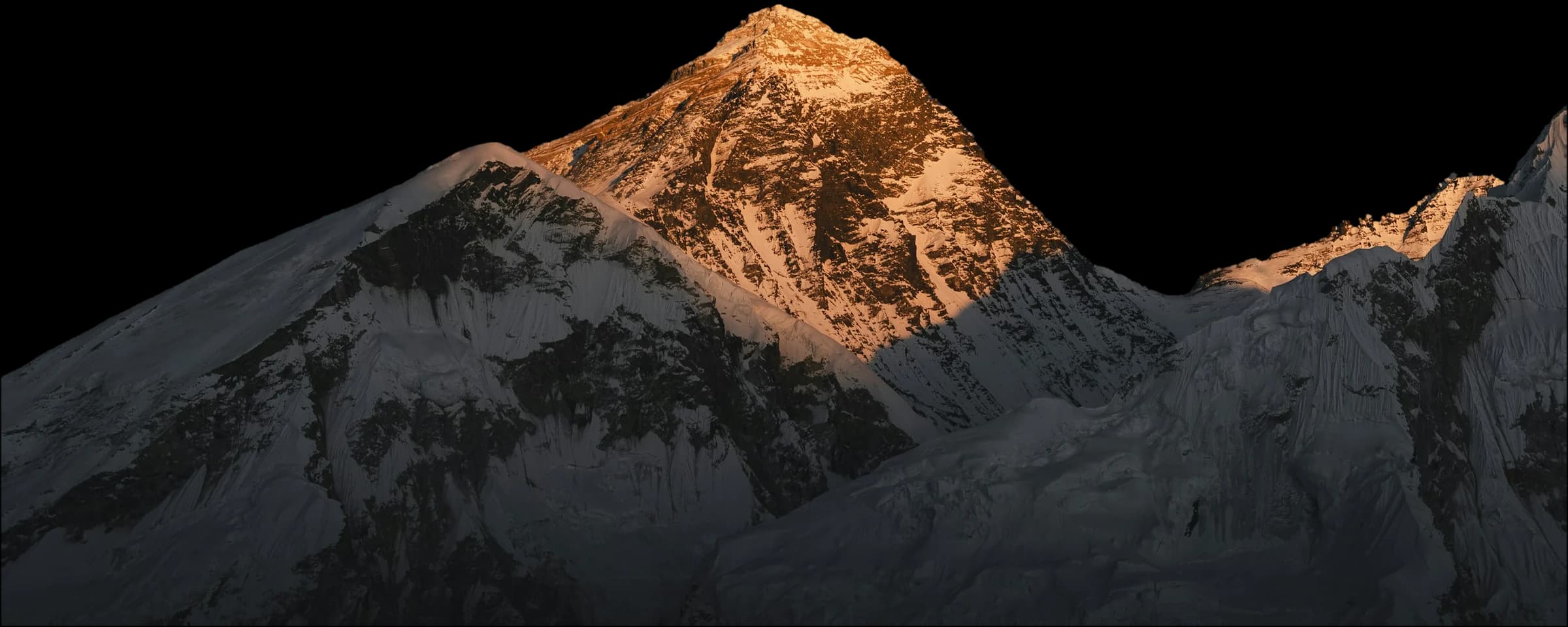 Mount Everest from the Nepal side, its summit lit gold above the Nuptse ridge